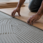 Mains posant lames de bois sur sous-couche grise